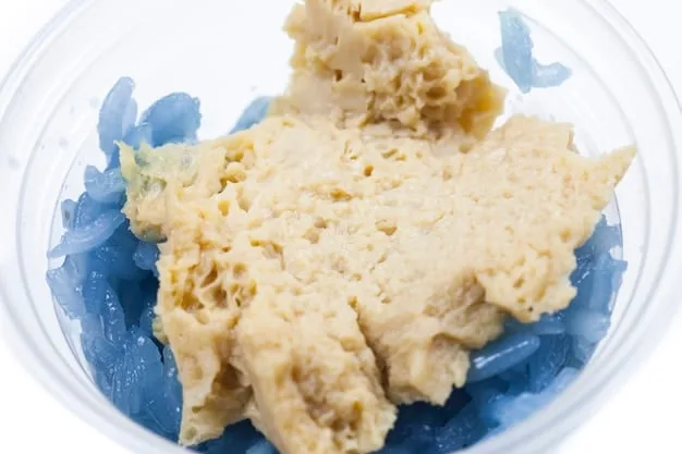 A close-up of a bowl of tempura batter, showing its light, slightly lumpy texture and the icy cold water being used.