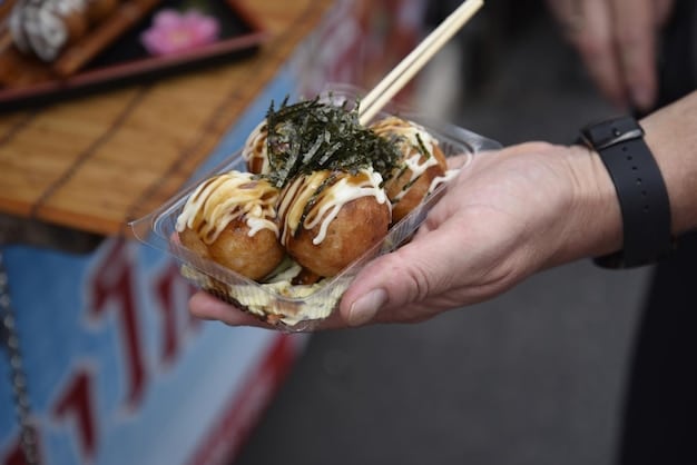 A close-up shot of a vendor selling takoyaki (octopus balls) at a Japanese festival, with steam rising and people queueing to buy the snack.