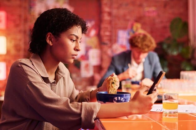 A person sitting at a traditional Japanese restaurant, using the Gurunavi app on their smartphone to read the menu, which is displayed in both Japanese and English. The table is set with various Japanese dishes, such as sushi, tempura, and ramen.