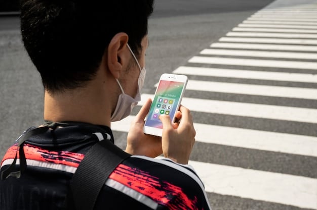 A person using a smartphone with an emergency alert application open, displaying information about a nearby earthquake in Japanese and English.