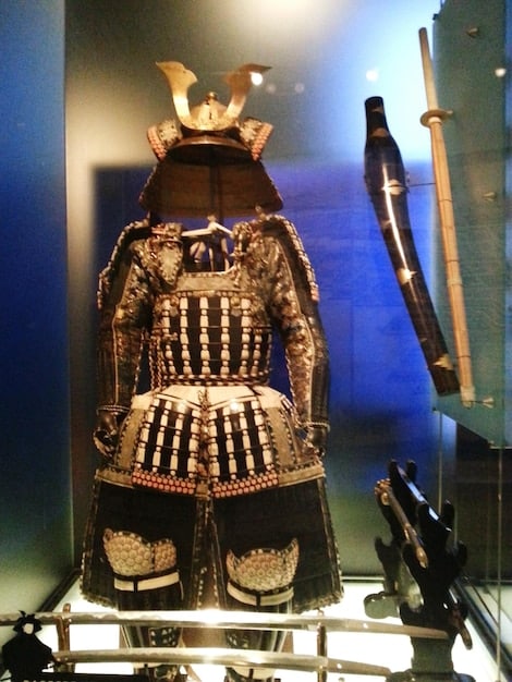A detailed view of a meticulously crafted samurai armor on display in a museum.
