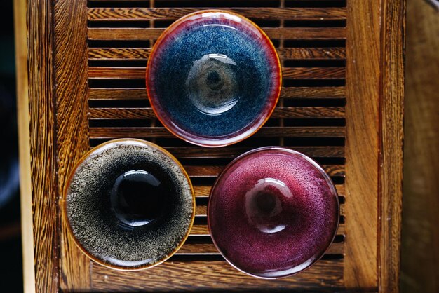 A close-up shot of a variety of beautifully crafted Japanese ceramics, including small bowls, teacups, and sake cups. The ceramics should showcase intricate designs and vibrant colors, highlighting the artistry and craftsmanship involved.