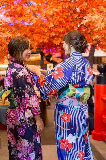Inside a specialty kimono shop, showing racks of colorful kimonos and a knowledgeable salesperson assisting a customer.