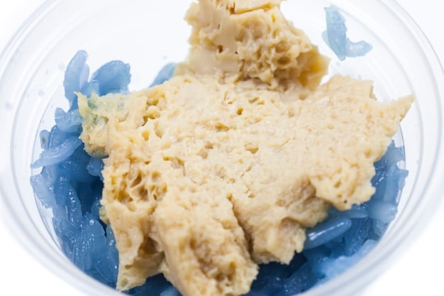 A close-up of a bowl of tempura batter, showing its light, slightly lumpy texture and the icy cold water being used.