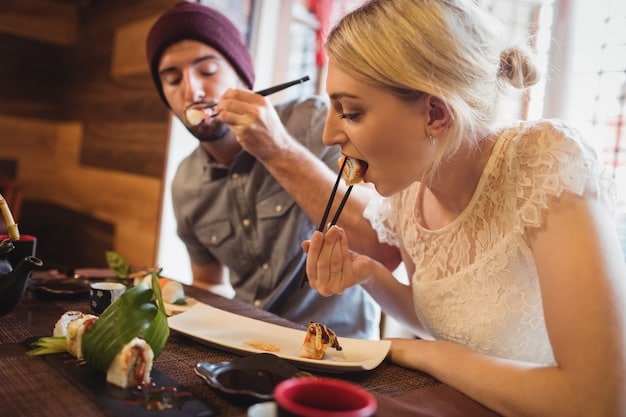 Two people sharing food at a Japanese restaurant, one person using their chopsticks to place food onto the other's plate.