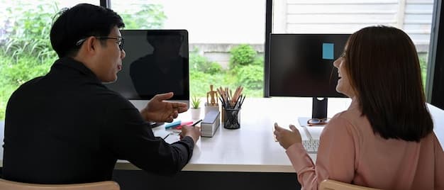 A Japanese office setting with several professionals working at their desks. One person is addressing a group, possibly in a meeting or giving instructions, indicating their leadership role.